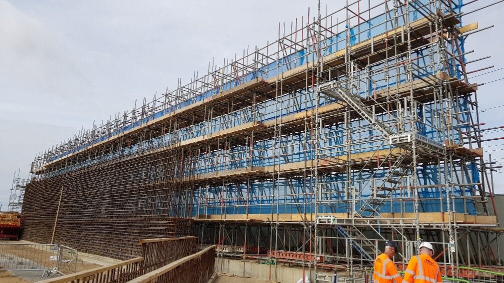 Multi-lift façade scaffold on a large industrial elevation